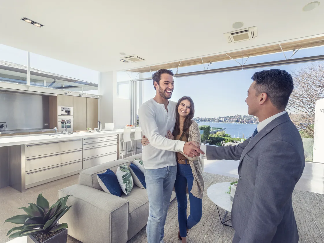 A Loanatik loan officer congratulating a couple in the kitchen of the home they just closed on