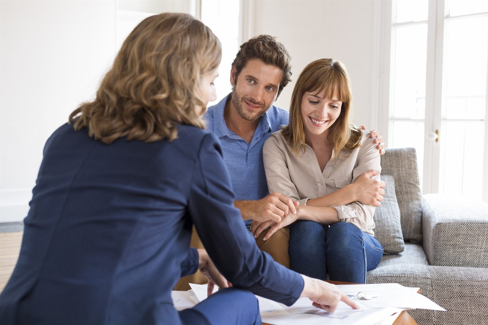 An advisor going through paperwork with a couple at home