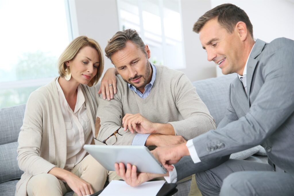 Advisors reviewing documents with clients on a sofa