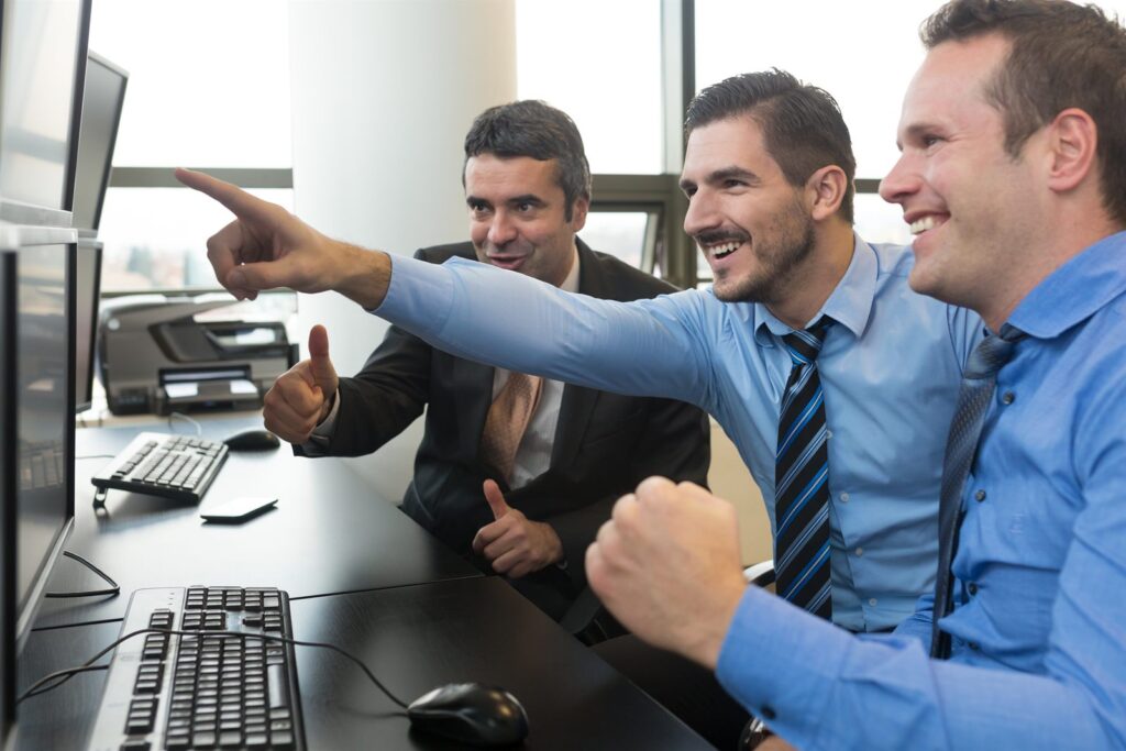 A team reviewing financial figures across multiple screens