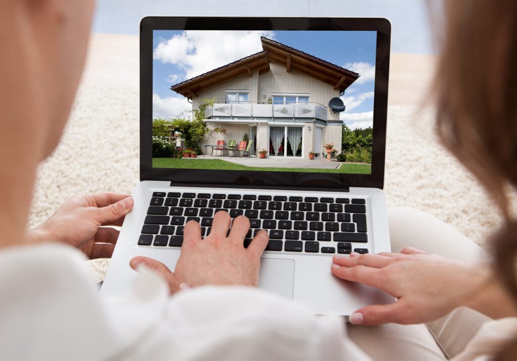Hands on a laptop showing a property listing