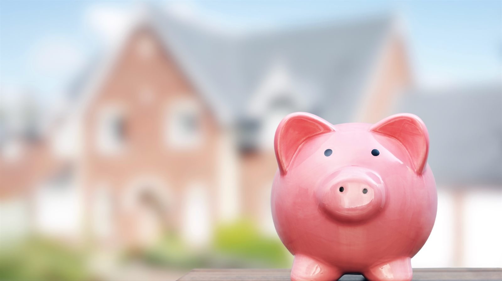 Piggy bank with a house blurred in the background