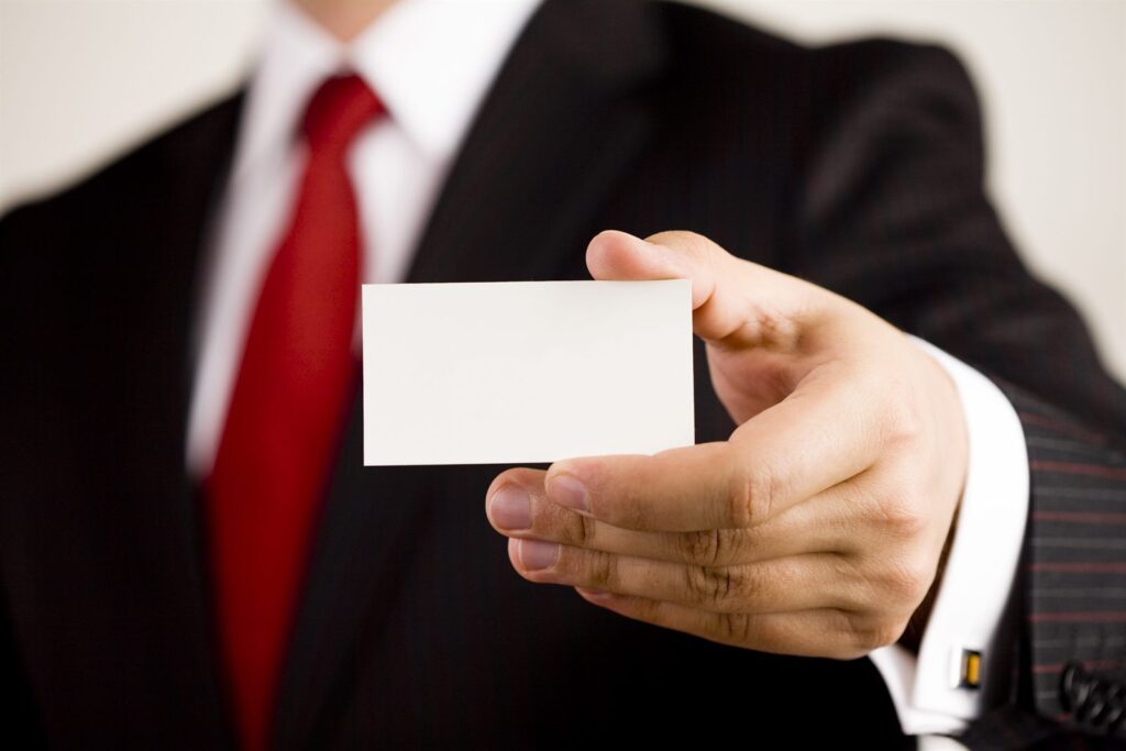 A business card passed between two people in suits