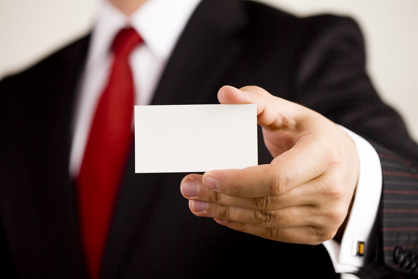 A business card passed between two people in suits
