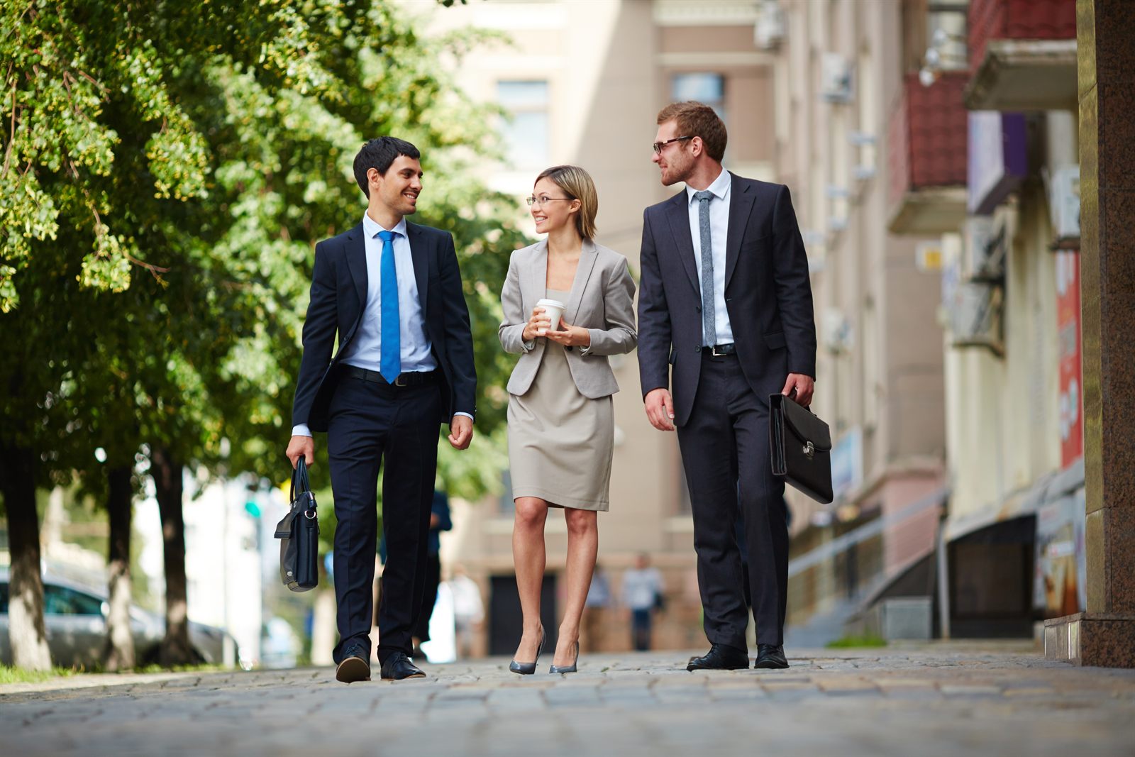 Three business colleagues walking along a city street