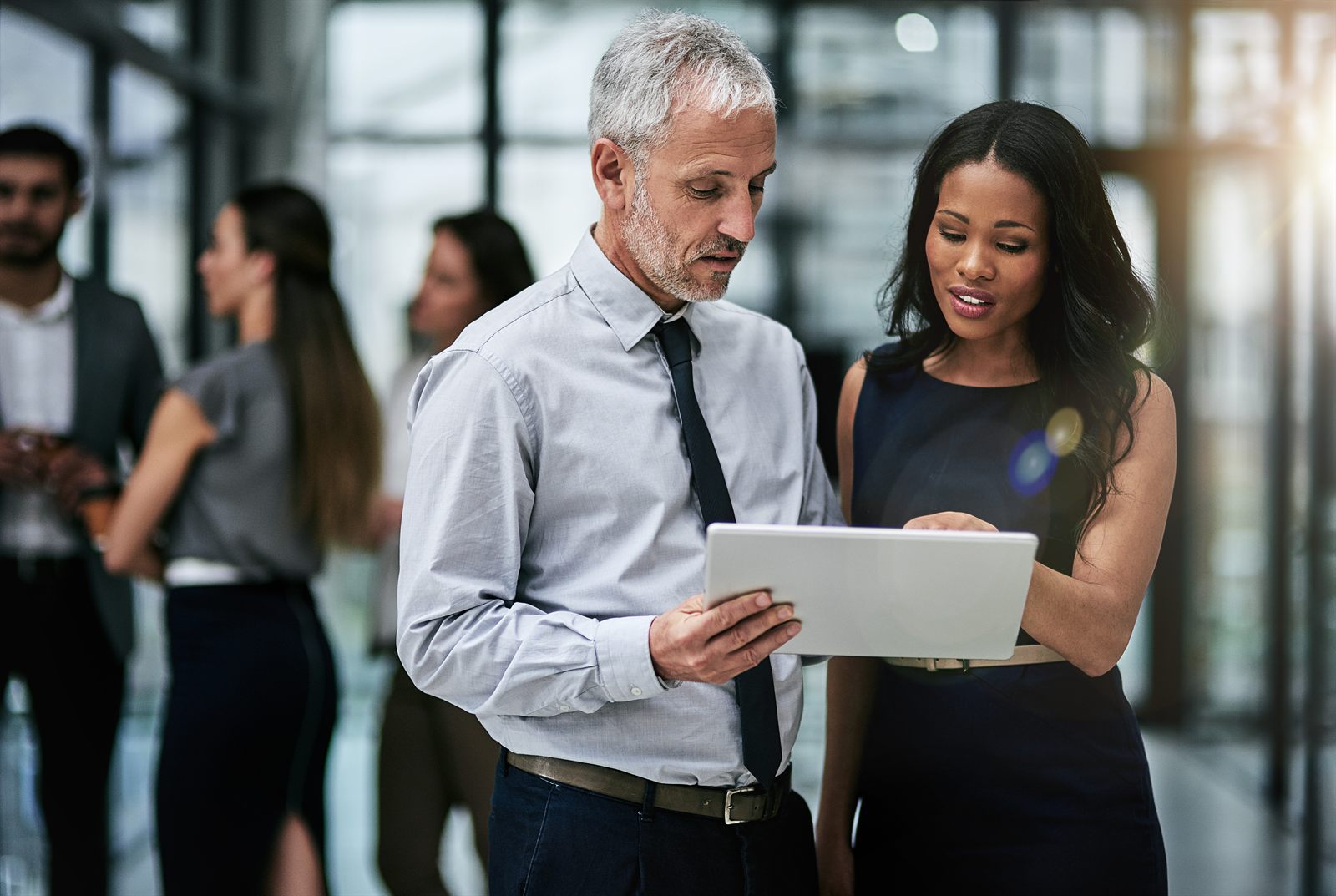 Two colleagues reviewing figures together on a digital tablet