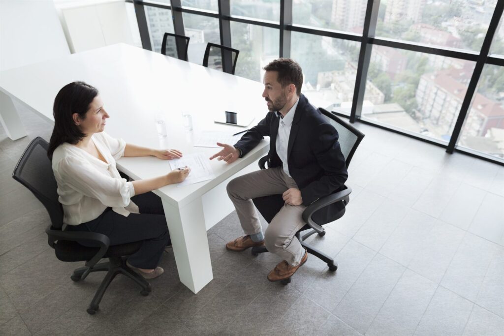 A presenter explaining figures to colleagues seated around a table