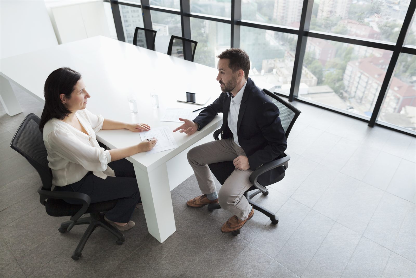 A presenter explaining figures to colleagues seated around a table