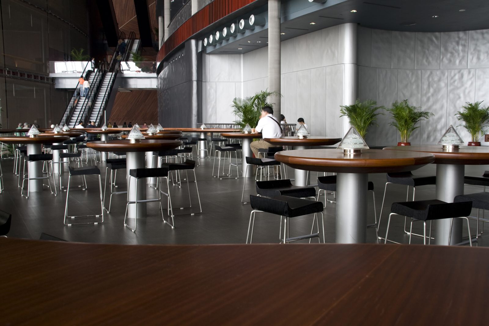 The empty interior of a small cafe with tables set under hanging lamps