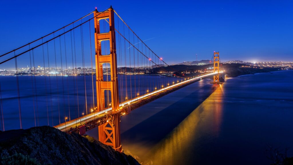 The Golden Gate Bridge lit at dusk above San Francisco Bay