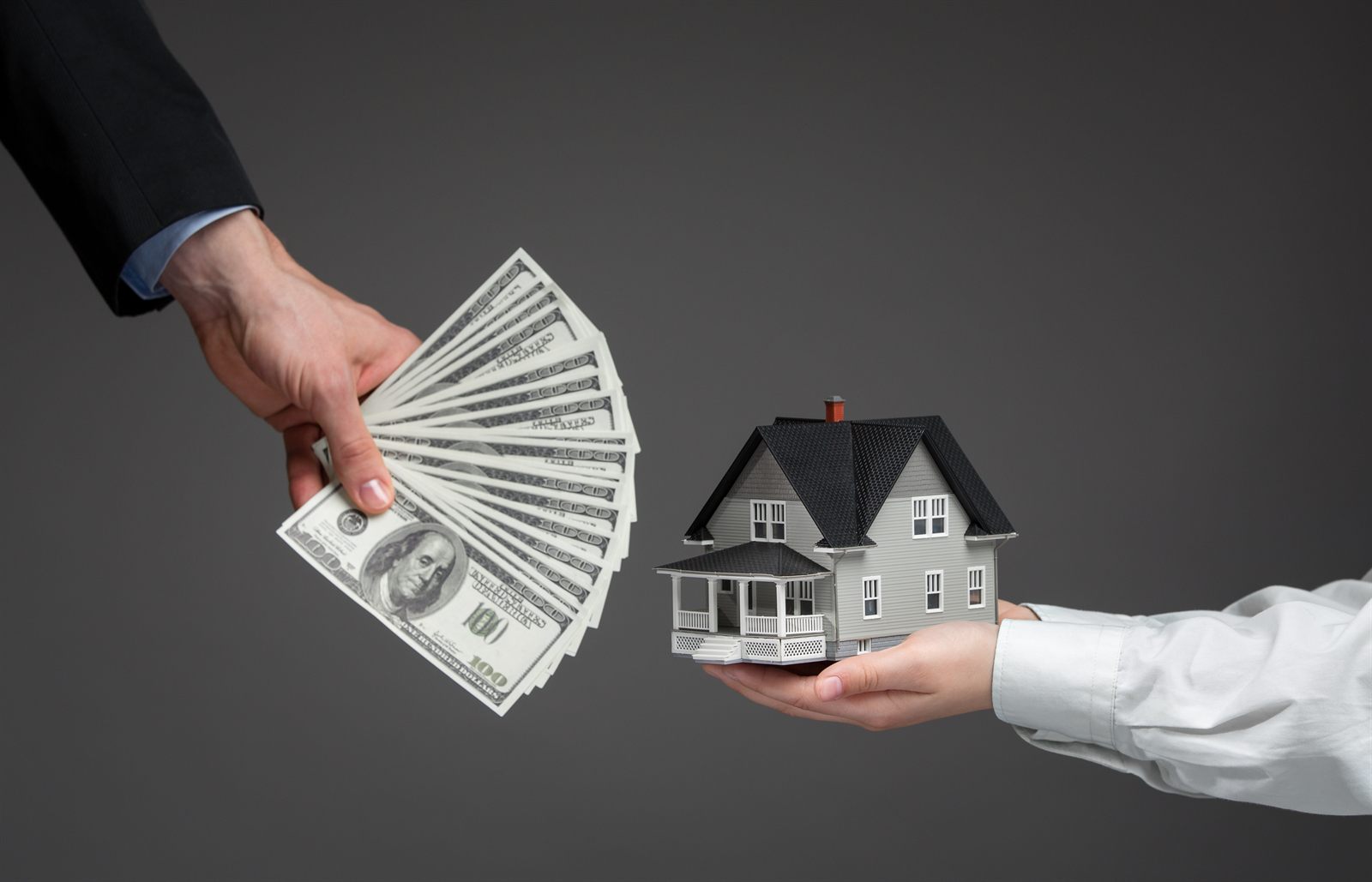 Hands passing house keys at closing