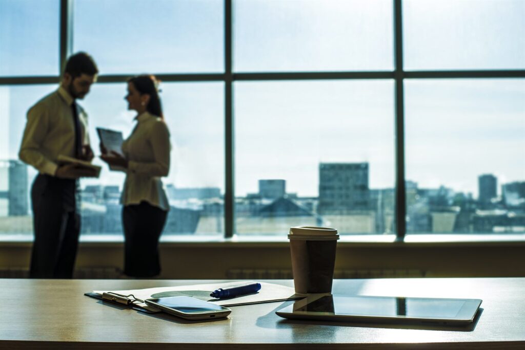 Two colleagues talking by a window in a modern office
