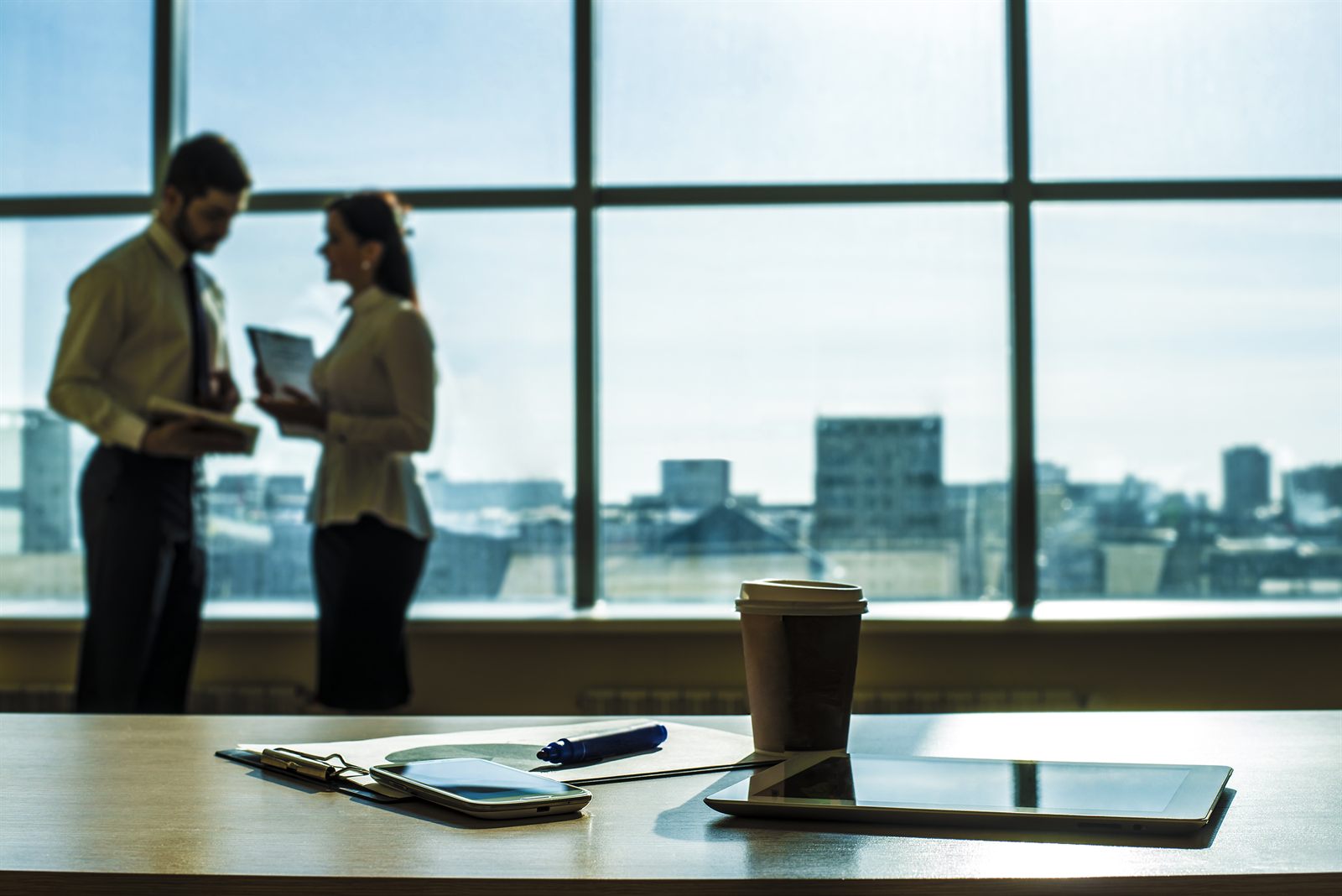 Two colleagues talking by a window in a modern office