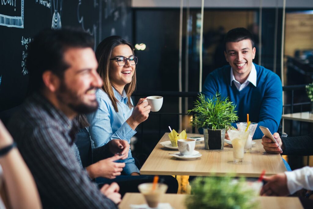 Colleagues talking around a table with coffee