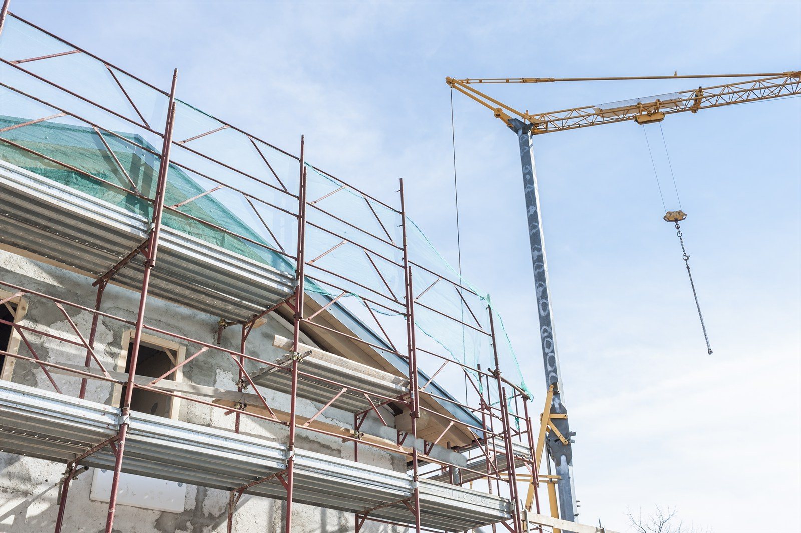 Scaffolding and a crane on a building undergoing renovation