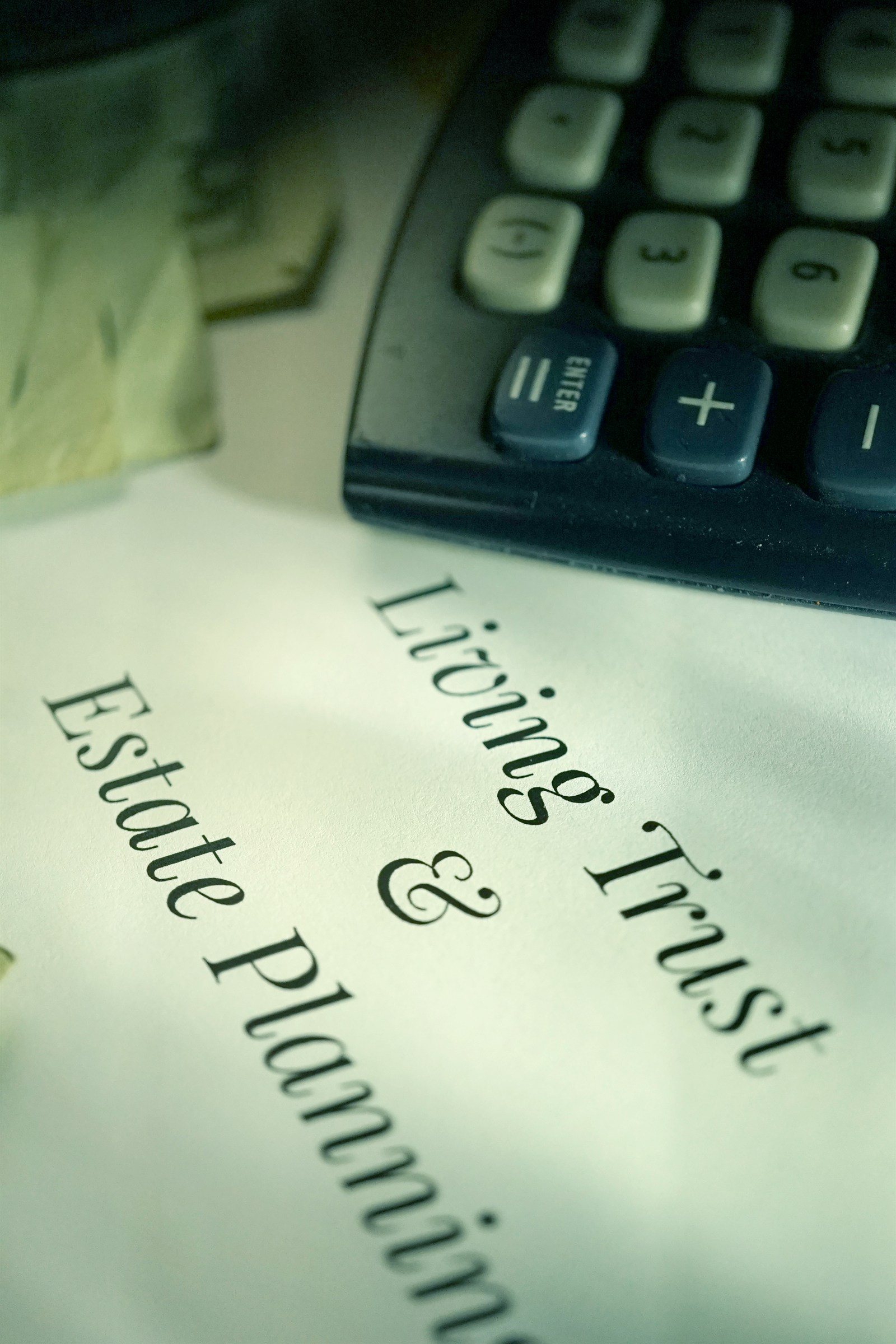 A living trust and estate planning document beside a calculator