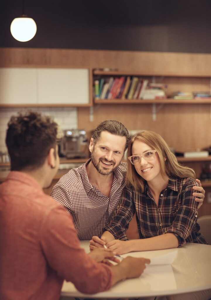 Couple sitting with an advisor reviewing paperwork