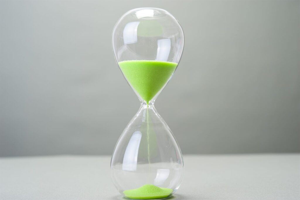 A green hourglass with the sand running through