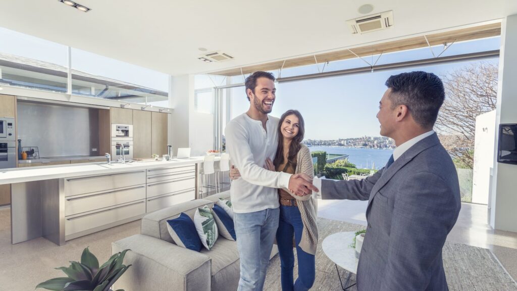 A loan officer congratulating a couple in the kitchen of their new home