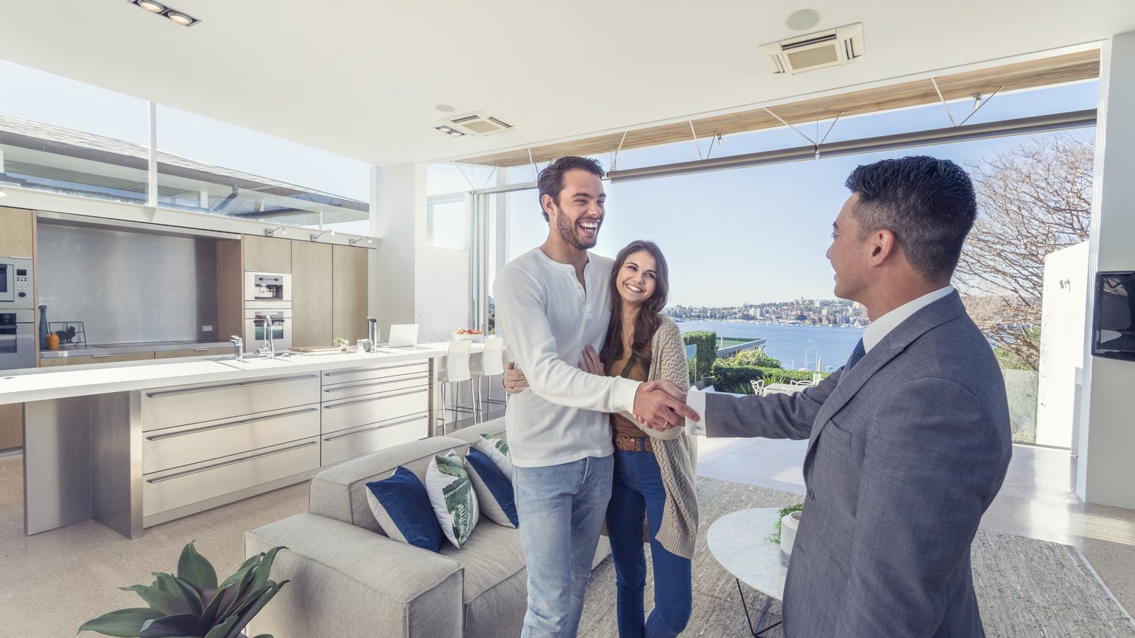 A loan officer congratulating a couple in the kitchen of their new home