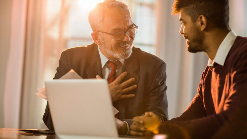 A mortgage advisor walking a client through loan options on a laptop