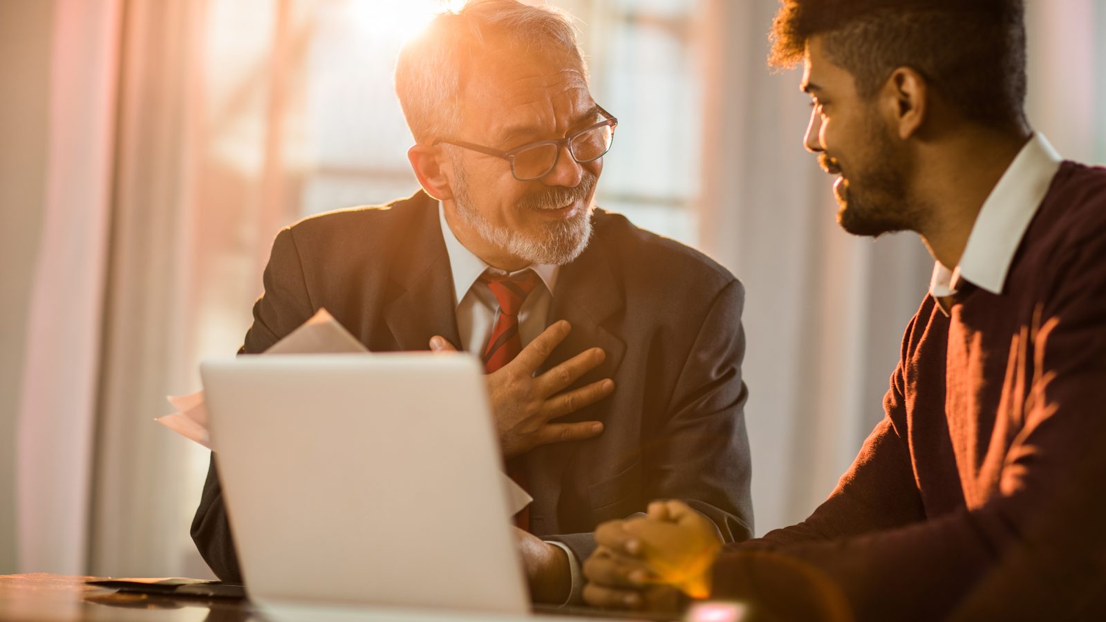 A mortgage advisor walking a client through loan options on a laptop
