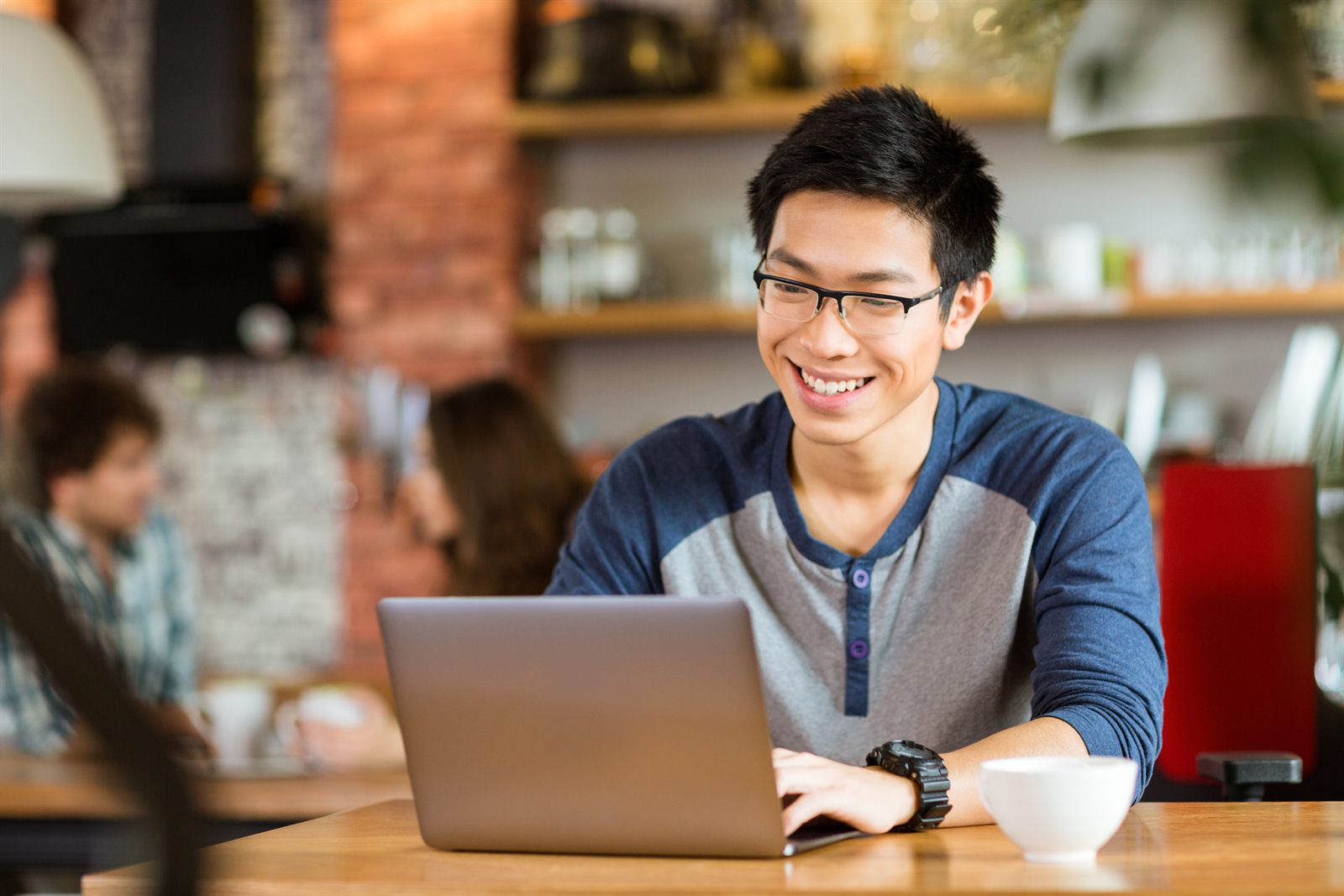 A small business owner working on a laptop at a cafe table