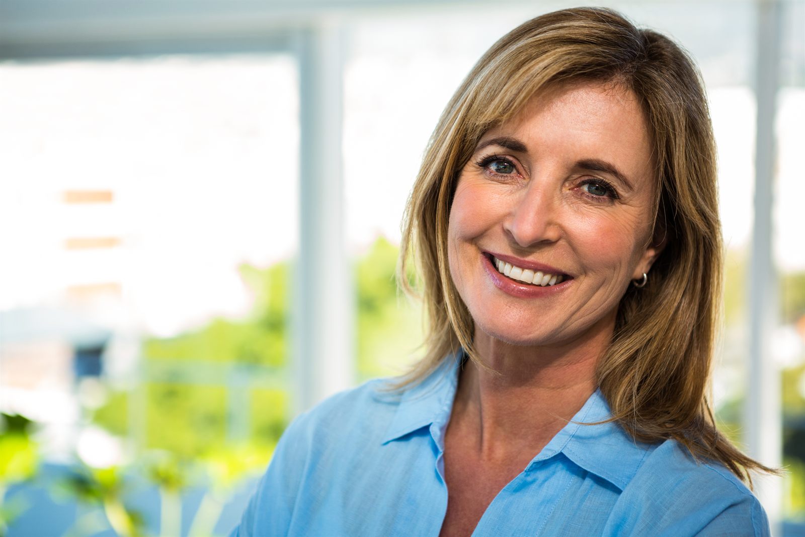 A professional woman smiling in a bright office