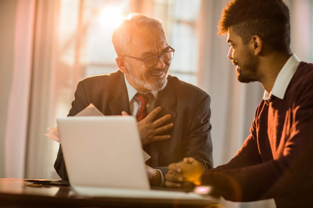 A mortgage adviser reviewing refinance options with a client at a laptop