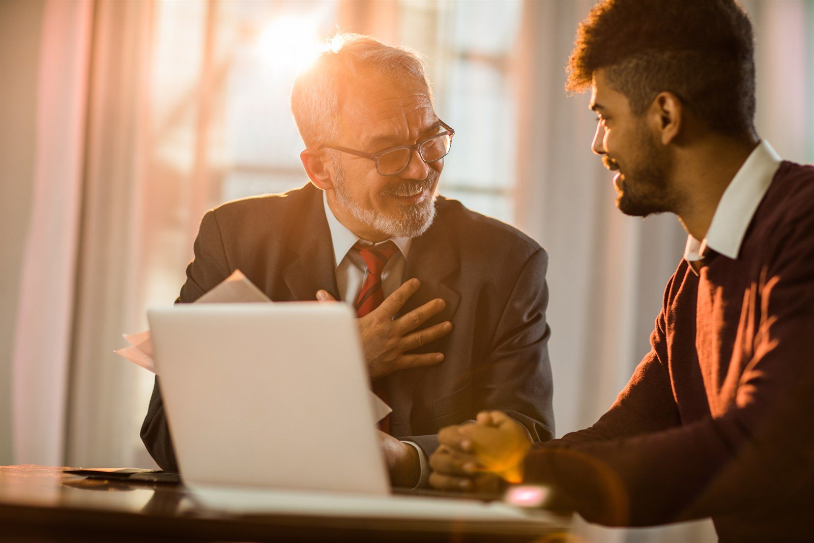 A mortgage adviser reviewing refinance options with a client at a laptop