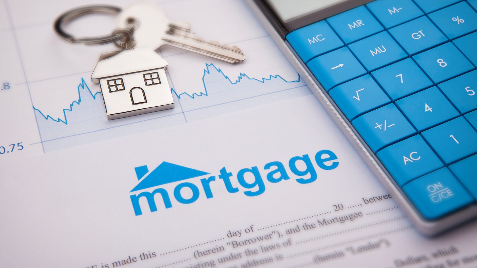 Mortgage paperwork with house keys and a calculator on a desk
