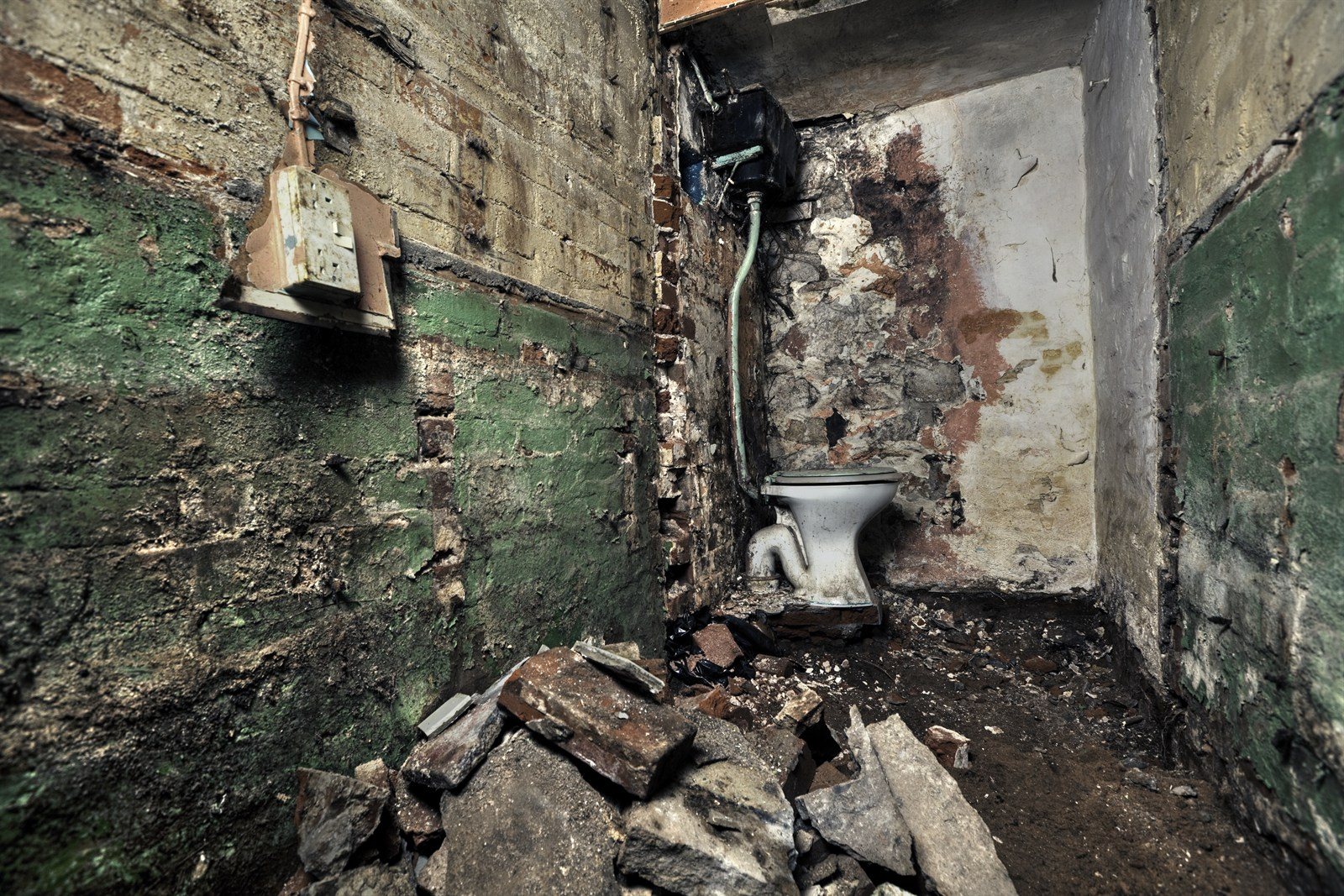 A derelict interior with crumbling walls and debris awaiting renovation