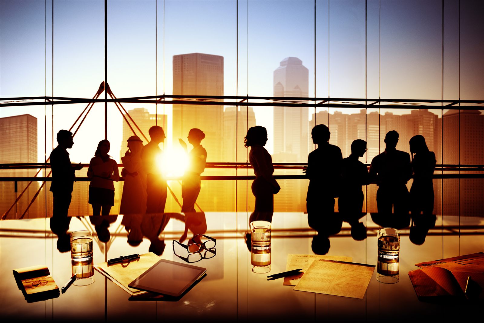 Silhouetted figures in a bright office atrium