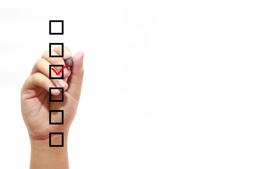 A hand ticking boxes on a printed checklist